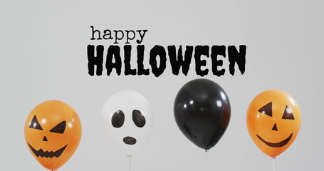 Happy halloween text banner over halloween pumpkin printed balloons against grey background - Powered by Adobe