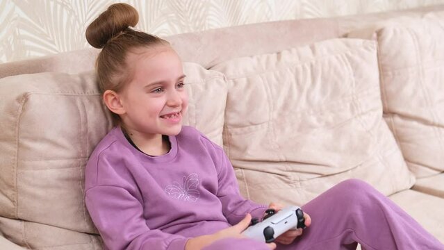 Young girl gamer controlling a PS controller. Home game console, modern technology, games, entertainment.