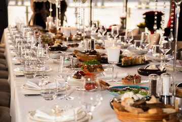 Serving the festive table at a wedding event. Decorating the wedding table with bouquets of flowers. Cutlery at a party