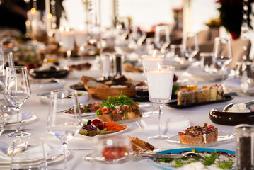 Serving the festive table at a wedding event. Decorating the wedding table with bouquets of flowers. Cutlery at a party