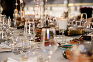 Serving the festive table at a wedding event. Decorating the wedding table with bouquets of flowers. Cutlery at a party