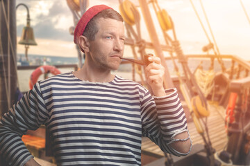 A sailor in a vest and a knitted red cap smokes a pipe.