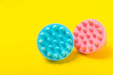 Brush for scalp massage on a yellow background. Brush for hair growth stimulating brush. Hair massage. stimulating brush. Hair care, head relaxation concept. Copy space.