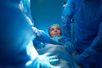 Woman patient waking up after operation in operating theater