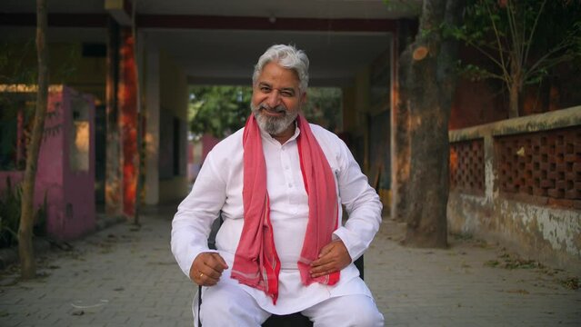 Old Indian man showing his strength and power in front of the camera - desi gabru  healthy farmer. Desi farmer flaunting his strong bones and posing for the camera - high protein  good calcium inta...