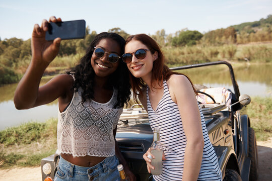 Women, selfie and vacation on road trip by lake, memory and travel adventure for social media in nature. Ladies, cellphone and profile picture in van on holiday, care and bonding together outdoor