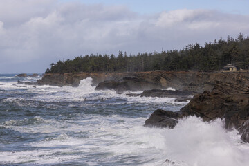 The ocean is rough and the waves are crashing against the rocks