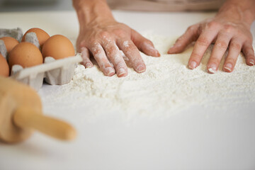 Baking, kitchen and hands with eggs with flour for cake, bread and pastry preparation in home. Culinary, baker and closeup of ingredients, wheat and person for recipe, dough and food on counter