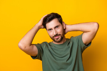 Obraz premium Photo of cheerful funky man wear khaki t-shirt smiling hands head isolated yellow color background