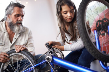 Father, child and bicycle for fixing chain as maintenance in garage for bonding together,...