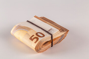 Bundle of 50 euro banknotes on a light background close-up.
