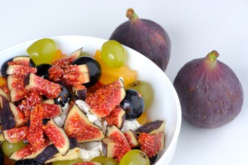Fruit Salad with Fresh Figs, Black and White Grapes and Cottage Cheese in Bowl on White