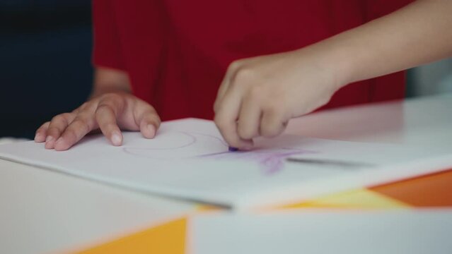 Close-up of a boy drawing a picture with crayons, creative hobbies for kids