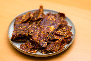 Jerky on the plate over the wooden table - 758122954