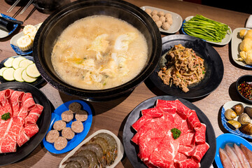 Hot pot with lots of food on the table - 758123768
