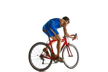 Obraz premium Side view image of concentrated sportsman in blue sportswear and helmet in motion on bike isolated on white studio background. Concept of sport, active and healthy lifestyle, speed, endurance, hobby