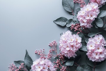 A floral backdrop featuring pastel pink hydrangeas and green leaves on the right side, set against a light blue-grey background. The photo includes copy space and follows a minimalist style flat lay.