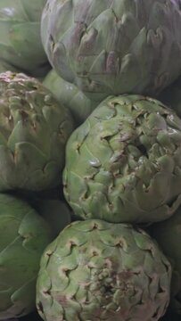 Take a vertical stack of fresh artichokes ready to cook.
