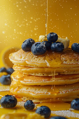 Flying pancakes with honey and blueberries. Yellow background