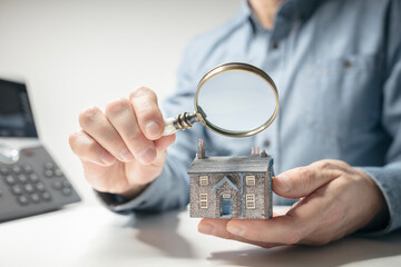 House model with man holding magnifying glass home inspection or searching for a house - 758127904