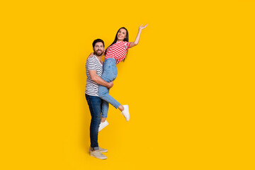 Fototapeta na wymiar Full length photo of boyfriend hold on hands pretty girlfriend hand hold object empty space isolated on vivid yellow color background