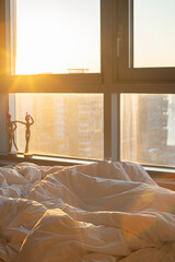 Comfortable bed in front of bright window
