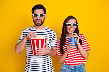 Photo of cheerful people enjoy movie premiere 3d glasses hold popcorn soda isolated on yellow color...