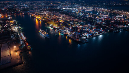 large cruise ship departing from Laem Chabang Port at night.  want to use low shutter speed to see movement of the ship. blue tone and over lighting scene photography aerial view.