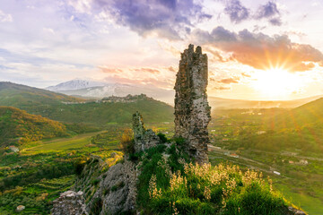 picturesque view from a mountain with ancient monument or castle ruins to a green valley with...