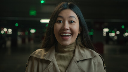Excited girl amazed reaction surprised face of Asian chinese korean japanese woman in car parking...
