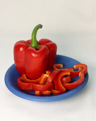 shiny red bell pepper on a blue contrasting plate
