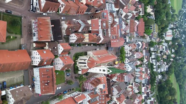 Beautiful view from above, from drone to orange, tiled roofs of houses. Top view of the German town of Bad Saulgau. The streets and roof of the church. Central Square of the city. Vertical view.