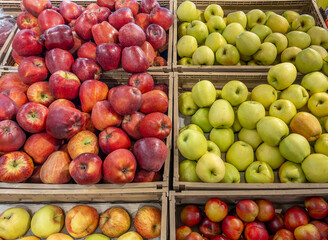 Red and green apples displayed in boxes on the greengrocer's stall in top view