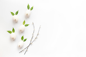 Easter background with white eggs in shape of bunnies with willow branches
