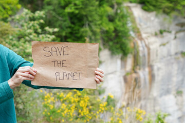 A person holding a sign that says "Save the Planet". Drought and Earth day