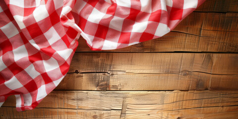 Obraz premium A red and white checkered tablecloth on a wooden background with copy space, banner