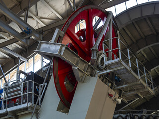  large red spinning wheel at the main station of the cable car