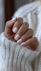Feminine hand with stylish white nail art and glitter manicure, pastel sweater fashion
