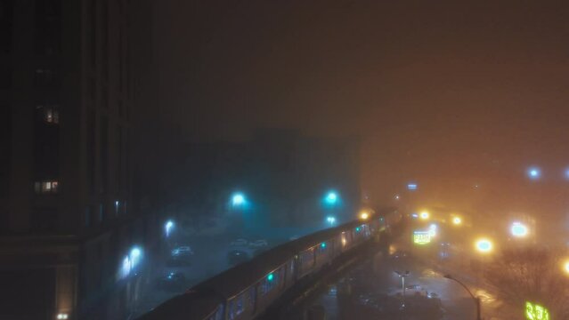 Train passing on Elevated Track at fogy Night. Subway in downtown Chicago downtown . Wide shot