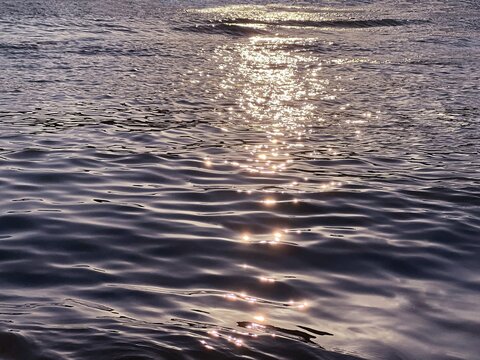 Sea glittering waves at sunset.
