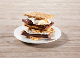 Smores on a plate with wood surface