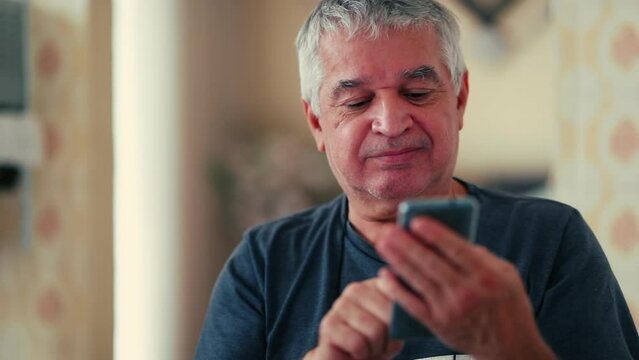 One elderly man reading positive message while holding cellphone device, close-up face of gray hair caucasian 70s male person nods in affirmation while staring at smartphone screen