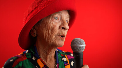 Funny closeup fisheye view of elderly woman singing enthusiastically into a microphone and dancing...