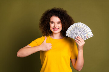 Photo of happiness wealthy young woman shopaholic thumb up like symbol banknotes salary for...