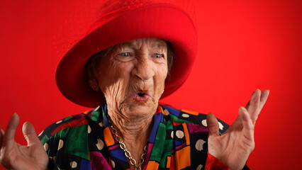 Slow motion view of concerned, unhappy elderly senior old funny crazy woman with wrinkled skin red...