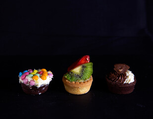 Three small colorful pastries against a black background