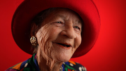 Smiling fisheye view caricature of funny elderly woman smiling with red hat and no teeth isolated...