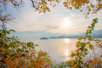 stunning autumnal scenery lake Traunsee, framed with leaves, passenger liner cruising