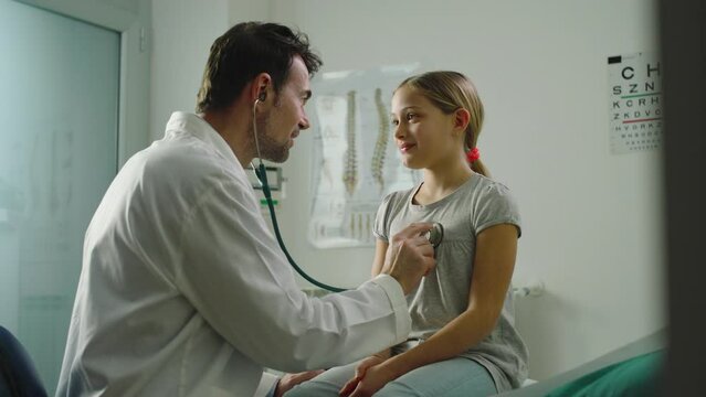 In a clinic, a doctor checks the health of a young girl and reassures her that she is in perfect health.
Prevention, medicine and health concept.