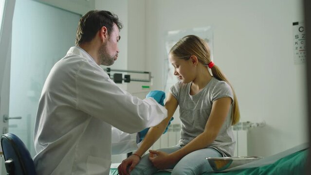 In a clinic or hospital, a doctor administers the vaccine to a little girl.
The doctor compliments the little girl on her courage.
Prevention, medicine and vaccines concept
